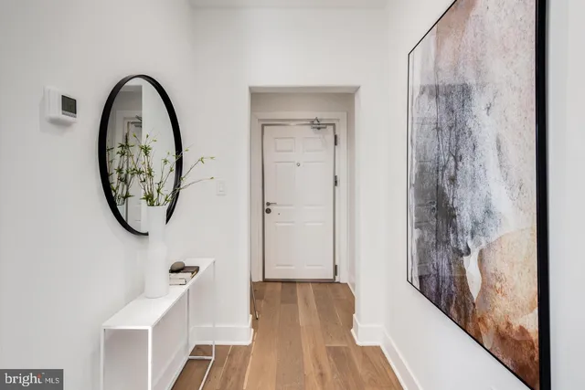 a view of a hallway with entryway wooden floor and front door