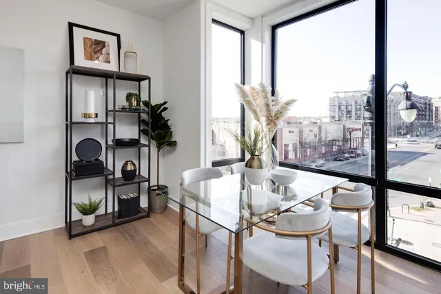 a dining room with furniture and a floor to ceiling window