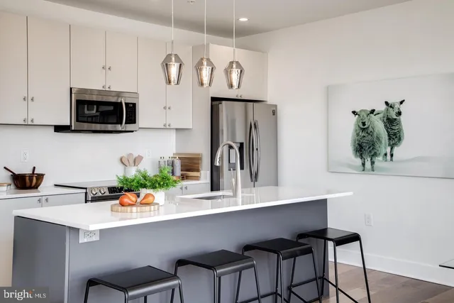 a kitchen with stainless steel appliances a microwave a sink and cabinets
