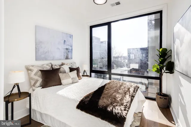 a bedroom with a large bed and a potted plant