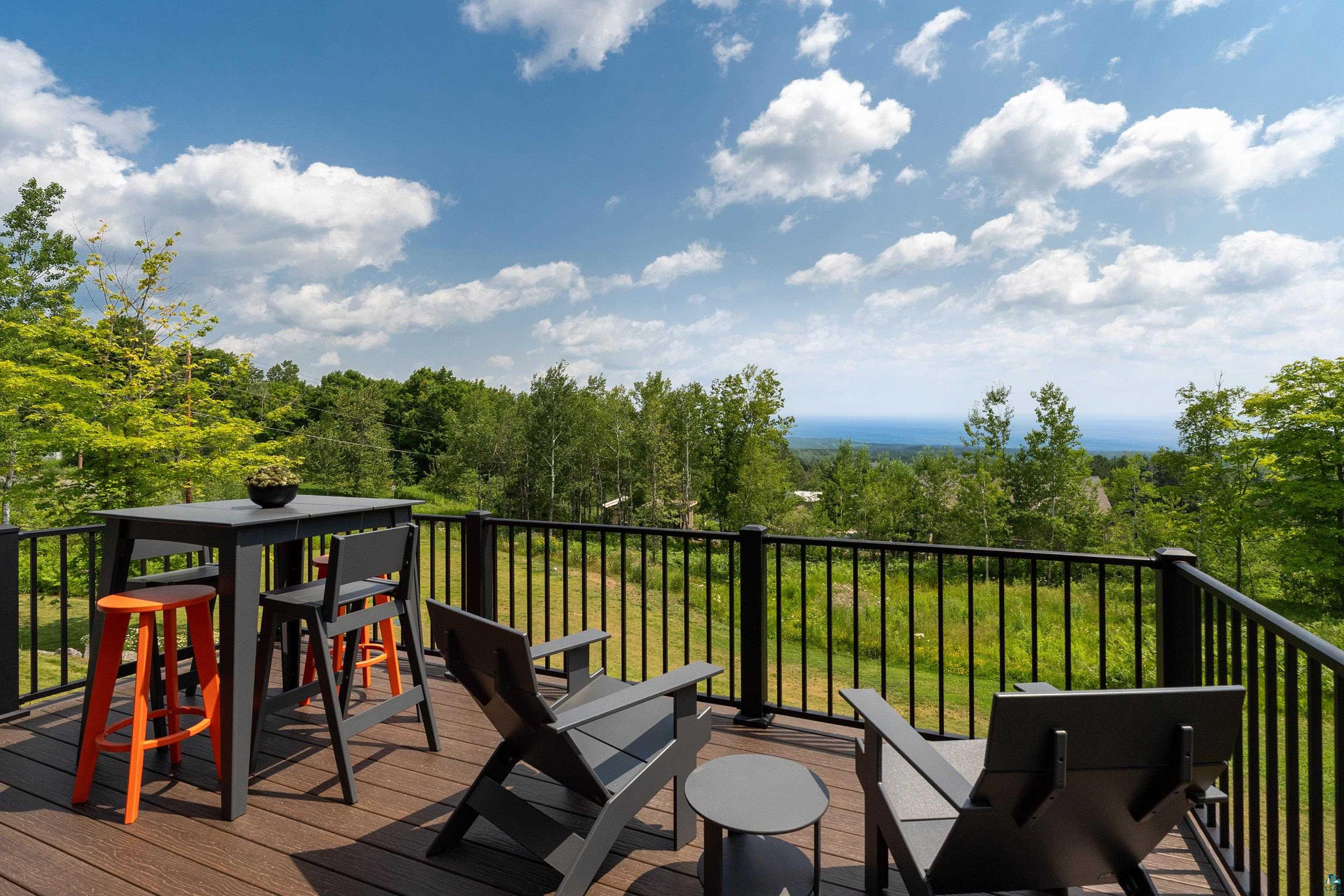 814 Pleasant View Road Duluth, MN 55803 - Photo 15 of 49 Deck featuring wood-finish flooring, black railing, and expansive tree-lined scenery