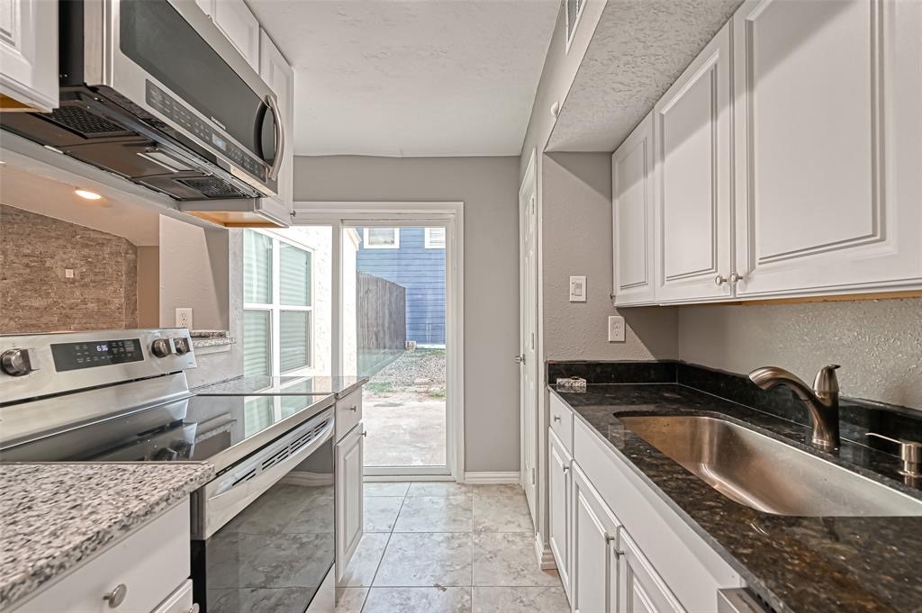 10252 Cottage Field Road Houston, TX 77041 - Photo 1 of 18 a kitchen with granite countertop a sink a stove and cabinets