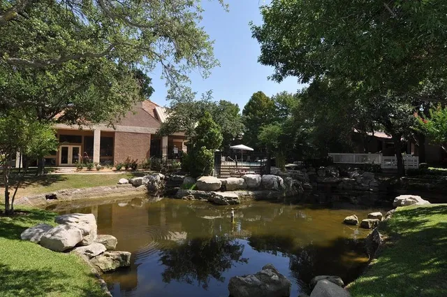 a view of swimming pool with lawn chairs and plants