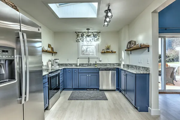 a kitchen with stainless steel appliances granite countertop a refrigerator and a sink