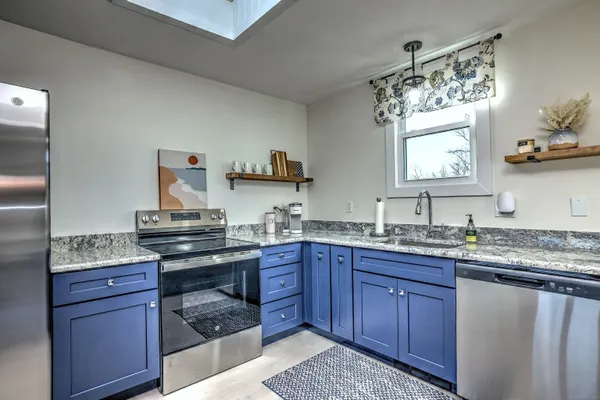 a kitchen with stainless steel appliances granite countertop a sink stove and cabinets