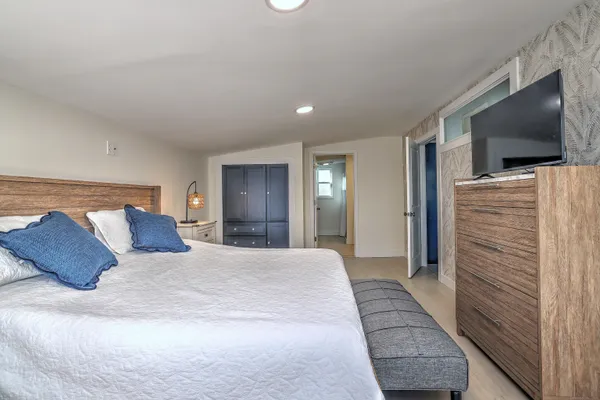 a bedroom with a large bed and a flat screen tv