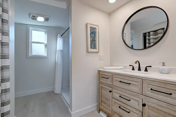 a bathroom with a granite countertop double vanity sink and a mirror