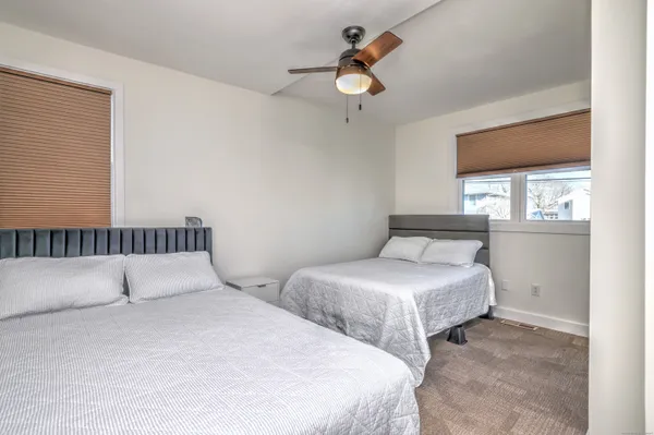 a bedroom with two beds and windows