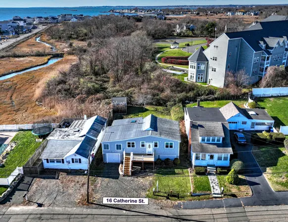 an aerial view of multiple houses with a yard