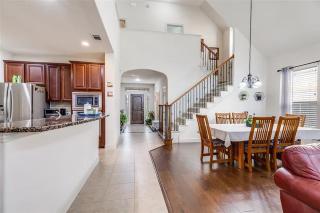 a dining room with wooden floor furniture and a kitchen