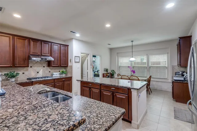 a kitchen with stainless steel appliances granite countertop sink stove top oven and cabinets