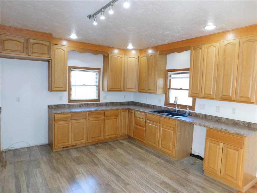 425 Vaneal Road Washington, PA 15301 - Photo 7 of 24 a kitchen with granite countertop wooden floors white cabinets and sink