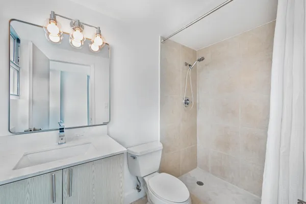 a bathroom with a sink a toilet and shower