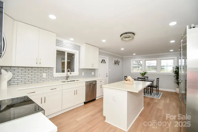 a large white kitchen with a large window