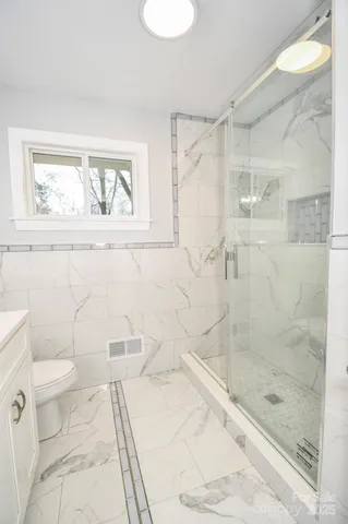 a bath room with a toilet and a shower