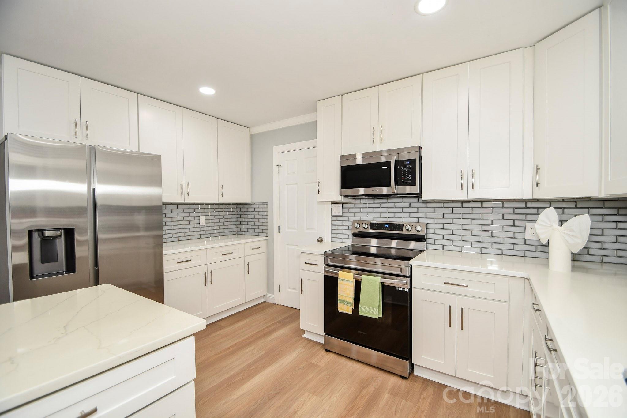 4517 Plyler Mill Road Monroe, NC 28112 - Photo 28 of 37 a kitchen with white cabinets and stainless steel appliances