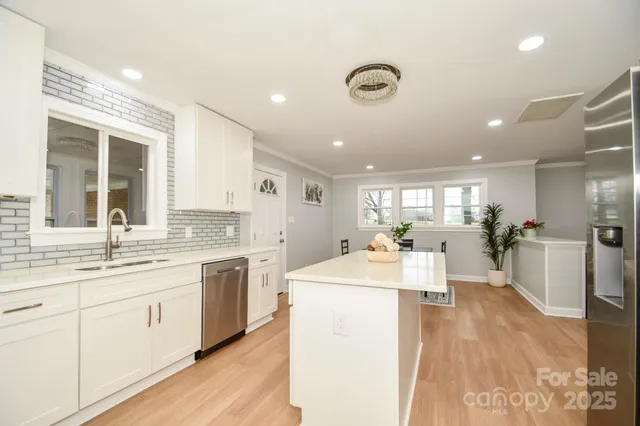 a large white kitchen with a lot of counter space and a sink