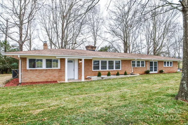 a front view of a house with a garden and trees