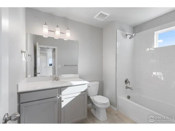 a bathroom with a sink a toilet a mirror and shower