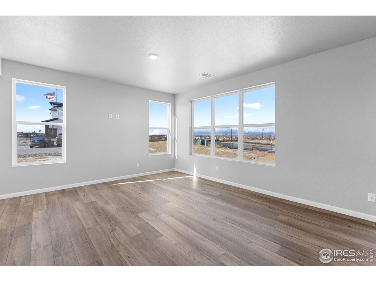6765 Utica Court Firestone, CO 80504 - Photo 10 of 23 a view of an empty room with a window and wooden floor