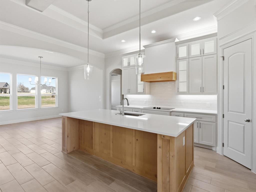3152 Infinity Drive Weatherford, TX 76087 - Photo 11 of 40 a kitchen with a sink a stove a refrigerator and white cabinets