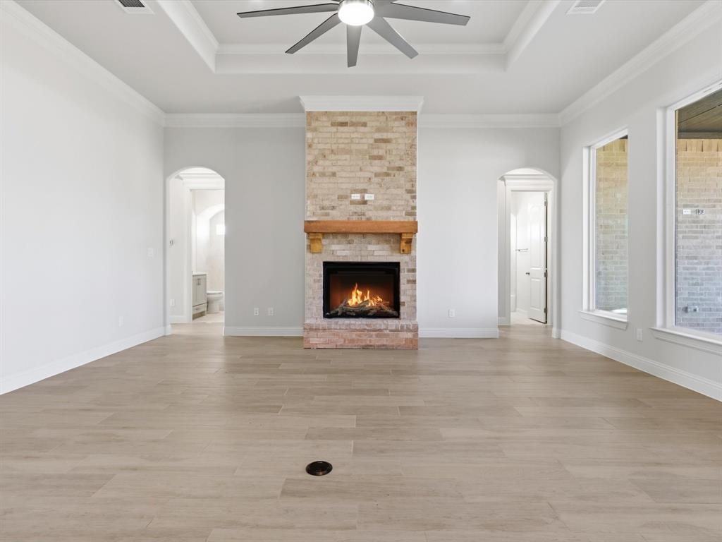 3152 Infinity Drive Weatherford, TX 76087 - Photo 23 of 40 a view of an empty room with a fireplace and a chandelier fan