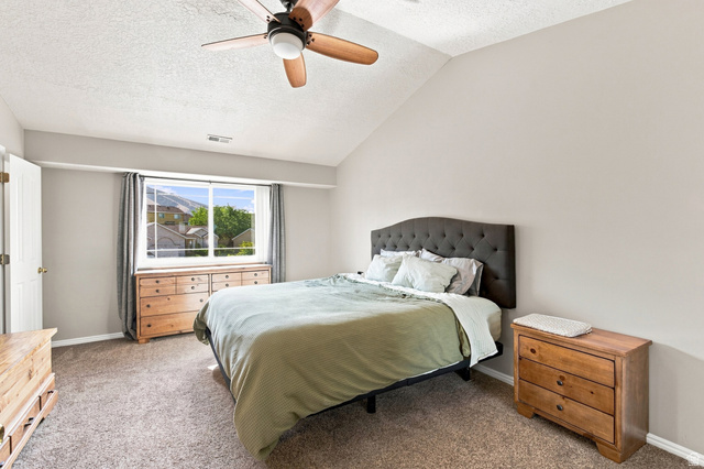 11882 Pond Ridge Drive Draper, UT 84020 - Photo 19 of 49 Angled vaulted ceiling with a ceiling fan, light gray wall paint, and a large window