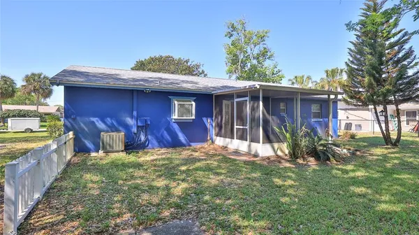 a view of a house with a yard chairs and floor to ceiling window