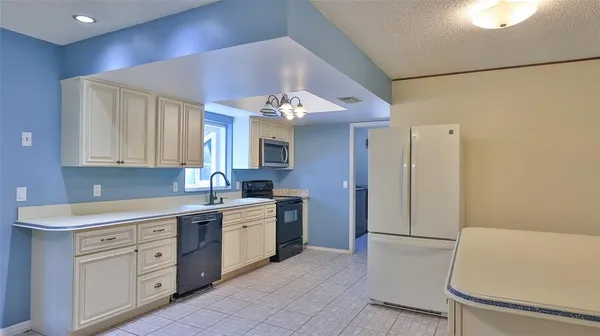 a kitchen with a sink a refrigerator and cabinets