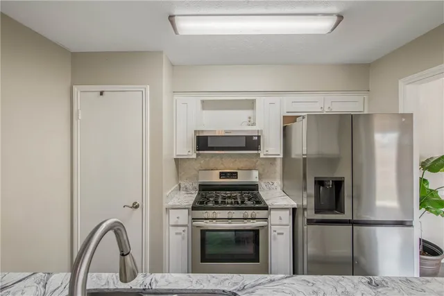 a kitchen with a refrigerator stove and microwave