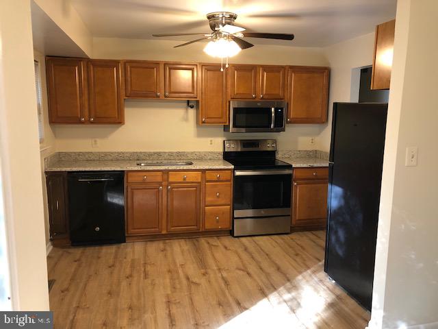 3604 4th Street North Beach, MD 20714 - Photo 8 of 14 a kitchen with stainless steel appliances granite countertop a refrigerator a stove top oven a sink and dishwasher