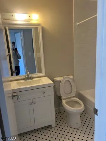 a bathroom with a toilet a sink and mirror