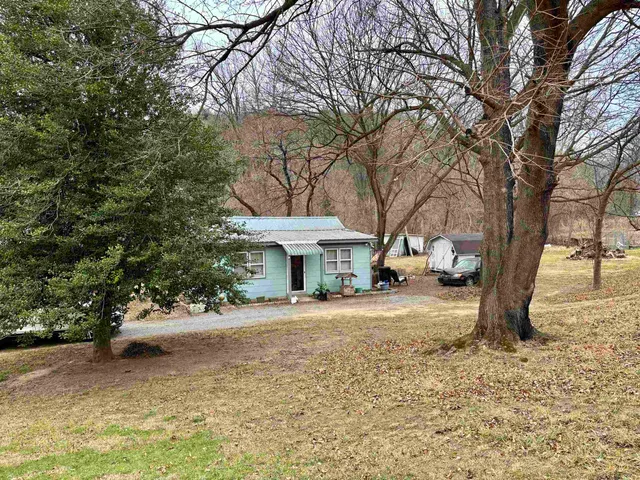 a front view of a house with a yard and trees