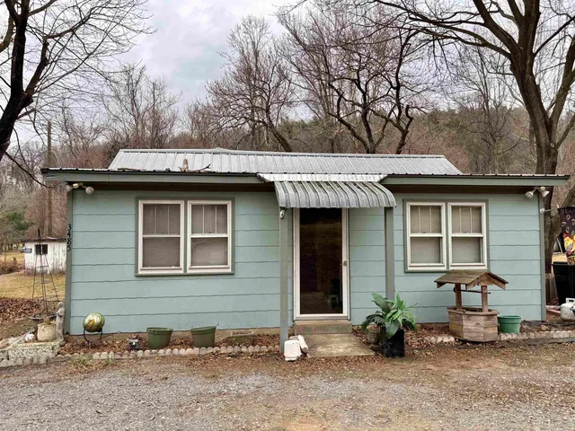 a view of a house with a yard and sitting area