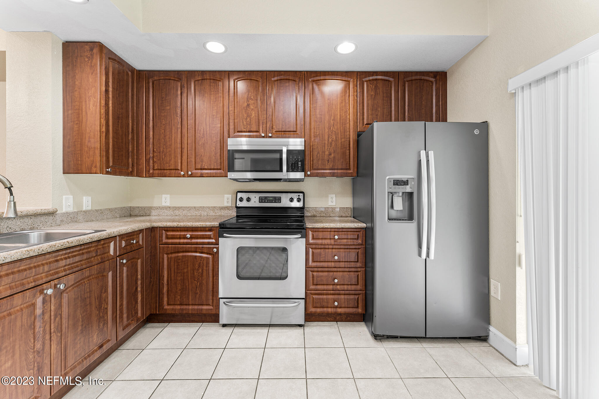 9745 Touchton Road, Unit 2003 Jacksonville, FL 32246 - Photo 12 of 34 a kitchen with a refrigerator sink and cabinets
