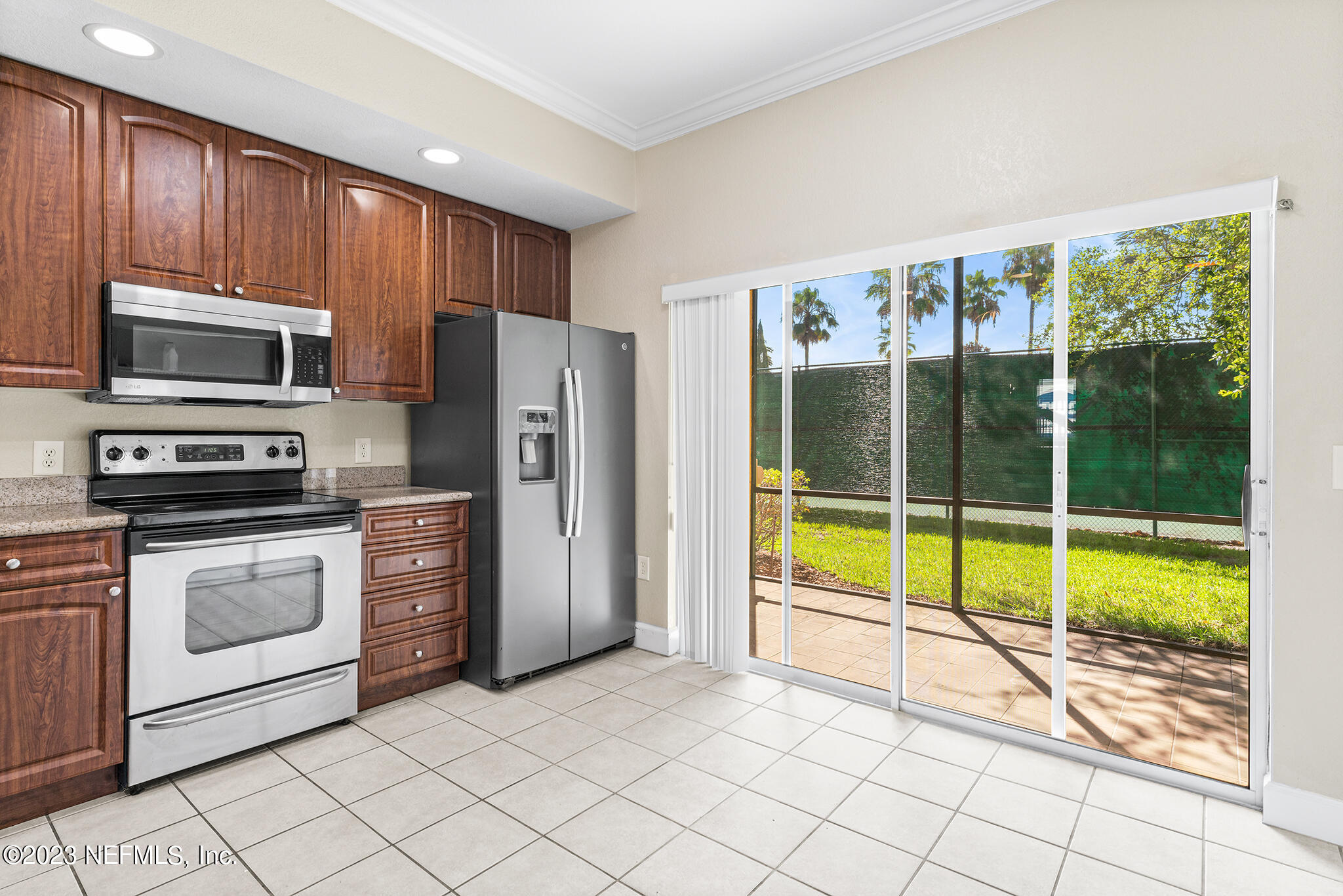 9745 Touchton Road, Unit 2003 Jacksonville, FL 32246 - Photo 10 of 34 a kitchen with stainless steel appliances a stove a refrigerator a microwave oven cabinets and a dining table