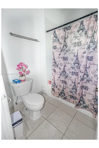 a bathroom with a toilet sink and shower curtain