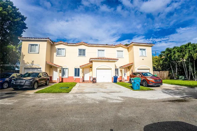 a front view of a house with a garden and parking