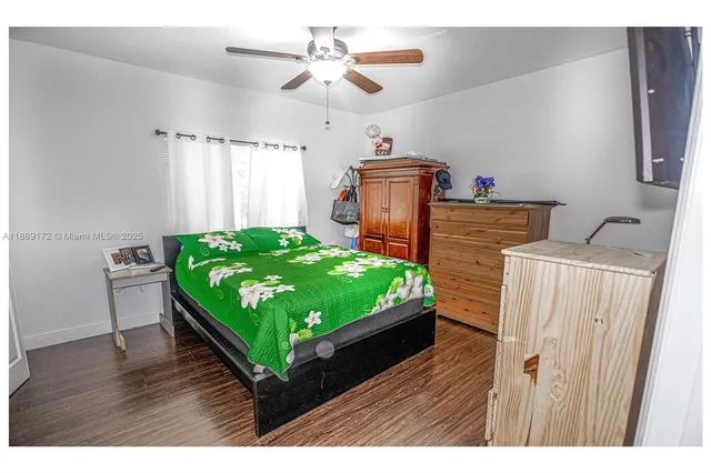 a living room with a bed furniture and a wooden floor