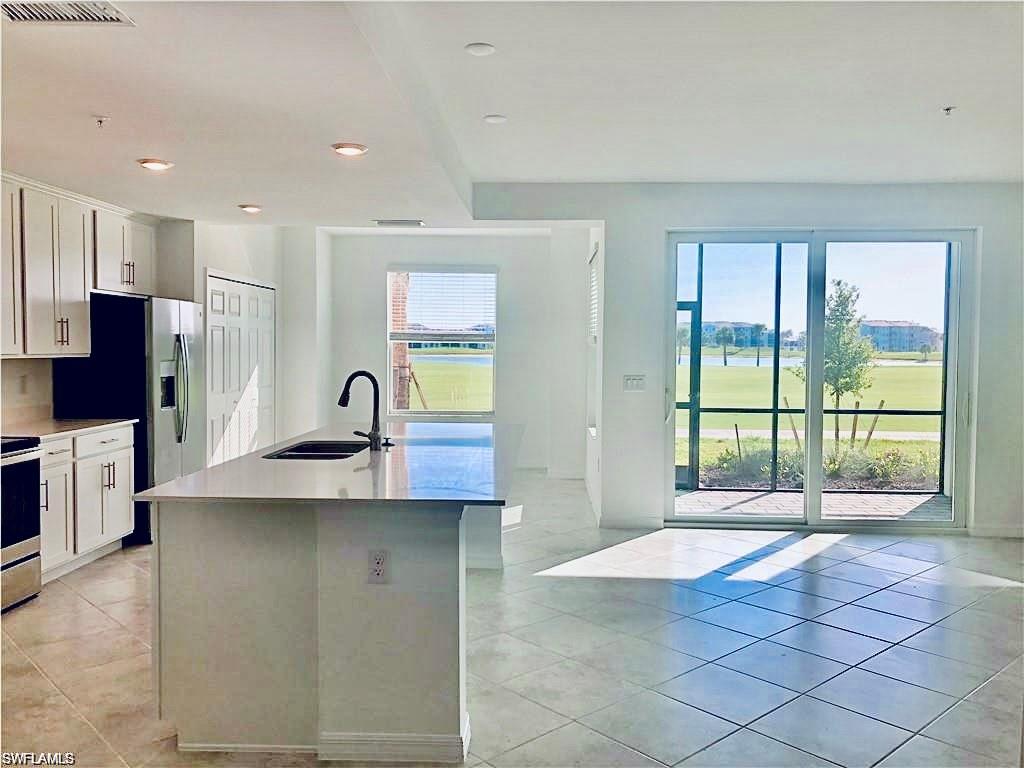 a kitchen with stainless steel appliances granite countertop a sink a stove and a refrigerator