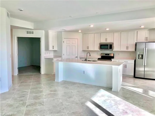 a kitchen with stainless steel appliances a refrigerator sink microwave and cabinets