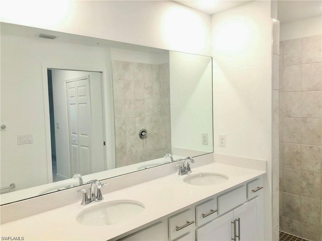 15960 Grassland Lane, Unit 2714 Babcock Ranch, FL 33982 - Photo 7 of 13 a bathroom with a double vanity sink and a mirror
