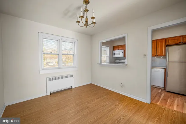 a view of empty room with wooden floor and window