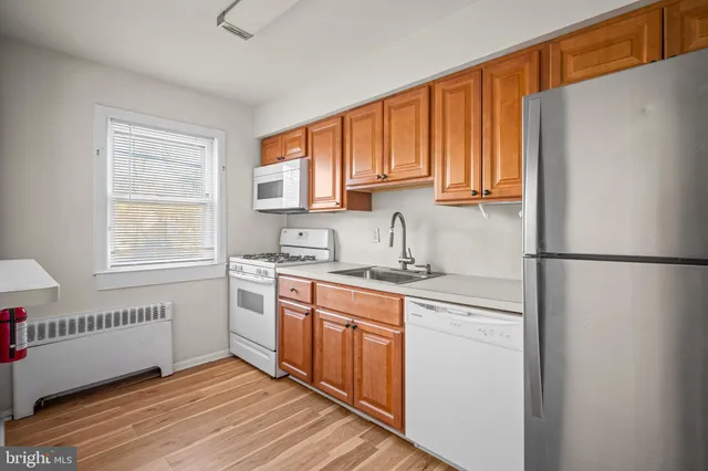 a kitchen with a sink cabinets stainless steel appliances and a window