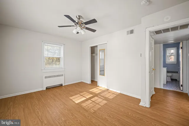 a view of empty room with wooden floor and window