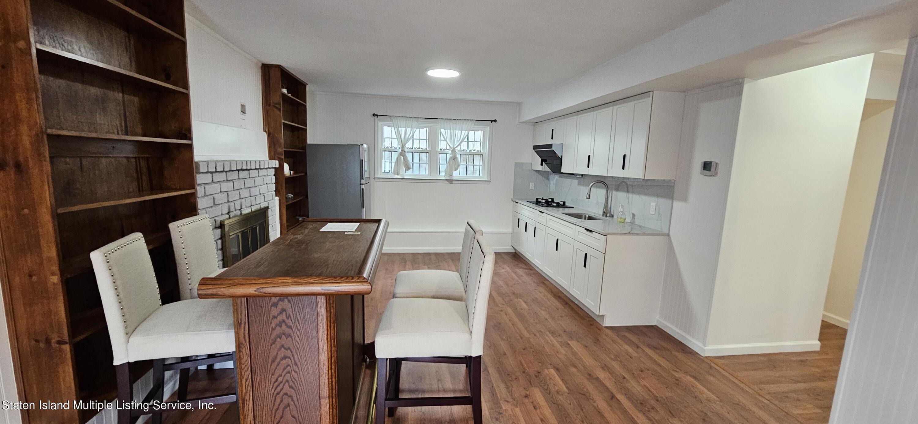 a kitchen with a table chairs refrigerator and a sink