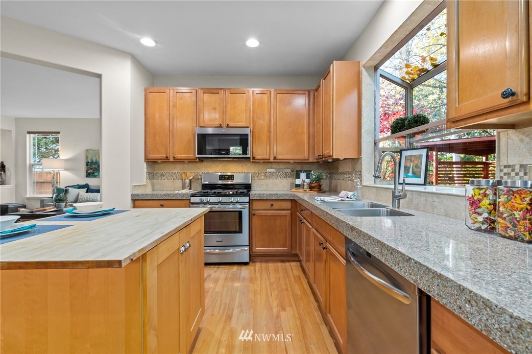 459 Field Place Northeast Renton, WA 98059 - Photo 6 of 40 a kitchen with stainless steel appliances granite countertop a stove a sink and a microwave