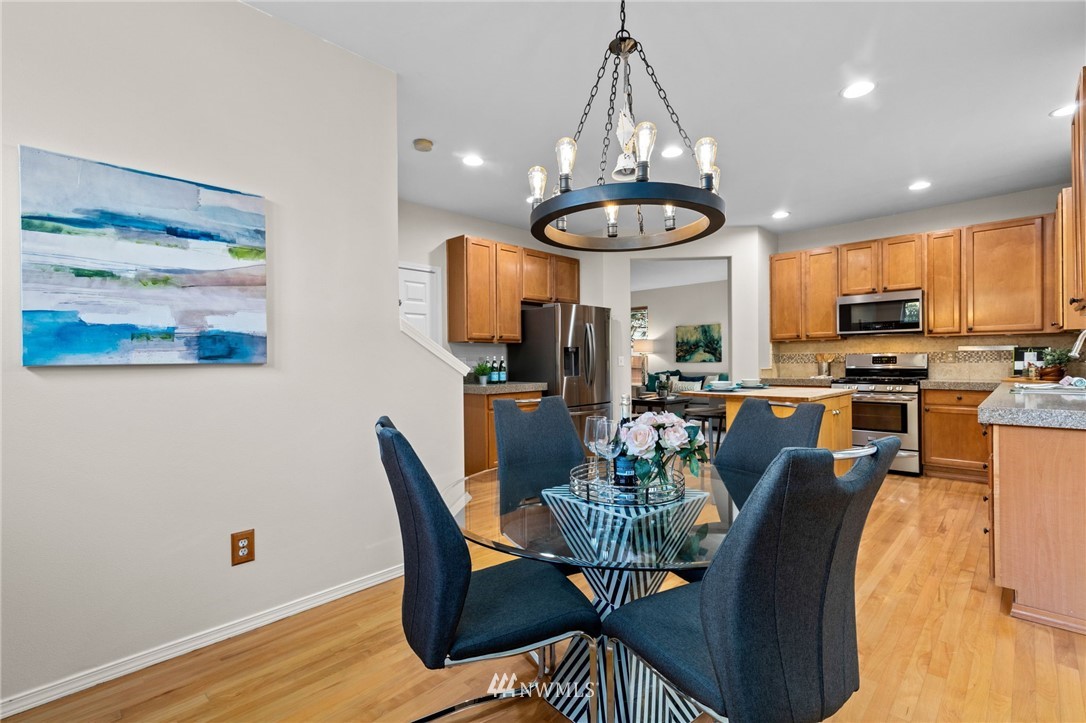 459 Field Place Northeast Renton, WA 98059 - Photo 9 of 40 a view of a dining room with furniture a chandelier and wooden floor