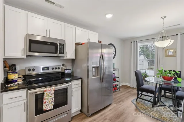 a kitchen with stainless steel appliances granite countertop a refrigerator microwave and stove top oven