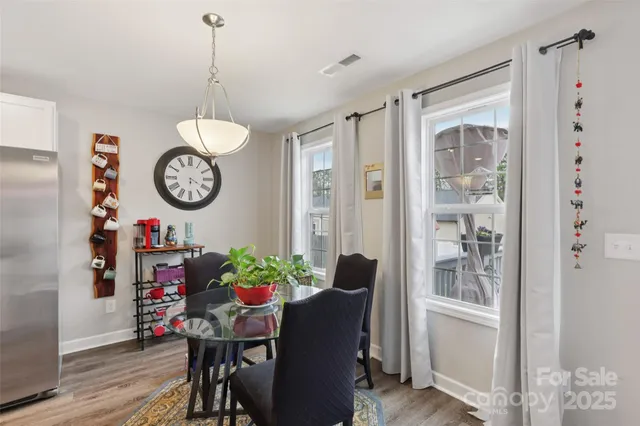 a view of a dining room and livingroom with furniture wooden floor a chandelier